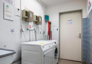 a laundry room with a washing machine and a door at Wohnung Nr 2 im Wikingerhof in Altfunnixsiel