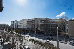 a city street with cars parked in front of buildings at Horizon Apartments, The Luxury Suites in Thessaloniki