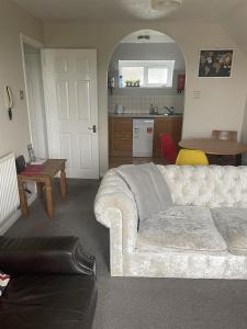 ein Wohnzimmer mit einem weißen Sofa und einem Tisch in der Unterkunft Weston Shore in Southampton
