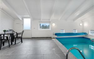 BjerregårdにあるOptimistenのテーブルとダイニングルーム付きの客室内のプールを利用できます。