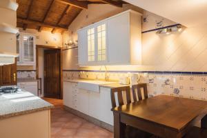 uma cozinha com armários brancos e uma mesa de madeira em Quinta do Outeiro em Resende