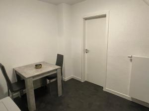 Zimmer mit einem Tisch, Stühlen und einer Tür in der Unterkunft Ferienwohnung Nähe Hbf Bremerhaven in Bremerhaven