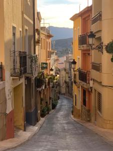 an alley in an old town with yellow and orange buildings at Las Puertas Del Indiano in Relleu