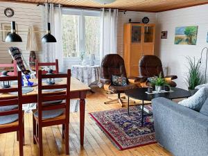 uma sala de estar com cadeiras e uma mesa e uma sala de jantar em Holiday home KORSBERGA II em Korsberga
