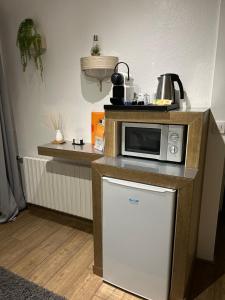 uma pequena cozinha com um micro-ondas e um frigorífico em Chambre d'hôtes de la Riaille 400 m de la dolce via em Le Cheylard