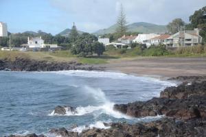 a beach with waves crashing on the rocks at Cantinho do Pópulo - Beach House in Ponta Delgada