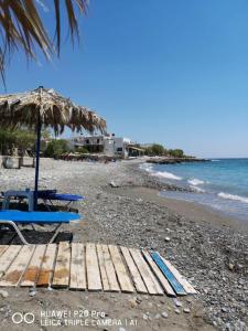 a beach with a picnic table and an umbrella at Casa Opuntia in Pappayiannádhes
