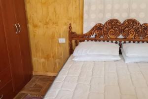um quarto com uma cama de madeira e 2 almofadas brancas em CABAÑA PARA RELAX EN OLMUE em Valparaíso