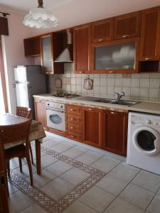 eine Küche mit einer Spüle und einer Waschmaschine in der Unterkunft Mare qui in Gaeta