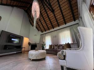 a living room with a couch and a tv at Rifumo Luxury Villa in Kruger Park Lodge in Hazyview