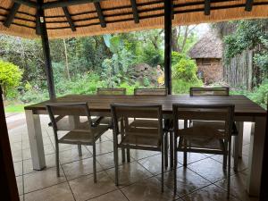 a dining room table with chairs and a large window at Rifumo Luxury Villa in Kruger Park Lodge in Hazyview