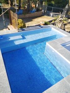 una piscina azul con un banco en un patio en Masia Tona, en L'Ampolla