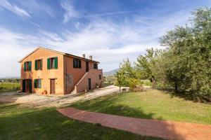 una casa en un campo junto a un árbol en Villa Collemancio la soleggiata, en Bevagna