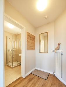 ein Bad mit einer ebenerdigen Dusche und einer Glastür in der Unterkunft Ferienwohnung mit Seesicht Grimmershörnbucht in Cuxhaven