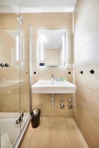 La salle de bains est pourvue d'un lavabo et d'une douche. dans l'établissement Ferienwohnung mit Seesicht Grimmershörnbucht, à Cuxhaven