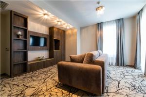 salon z kanapą i telewizorem w obiekcie Hotel Szatmári & Étterem Jászberény w mieście Jászberény