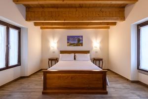 een slaapkamer met een bed en 2 ramen bij il Glicine B&B RISTORANTE in Cazzago San Martino
