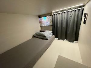 een kleine kamer met een bed en een raam bij Sleep&Go Hostel Ljubljana in Ljubljana