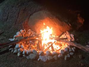 a fire pit with logs and rocks in it at Chalé Jacarandá - Hidro - Wifi e mais in Sapucaí-Mirim