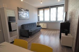 a living room with a couch and a television at KGHN Apartments Tkacka 28 in Szczecin