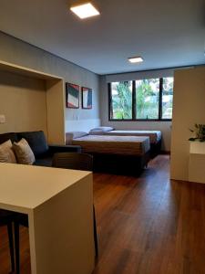 ein Wohnzimmer mit einem Sofa und einem Bett in einem Zimmer in der Unterkunft Villa Leopoldina - Studios de aluguel por temporada no Moinhos de Vento in Porto Alegre