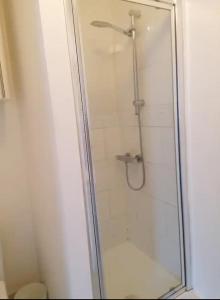 a shower with a glass door in a bathroom at Chantilly in Ickenham