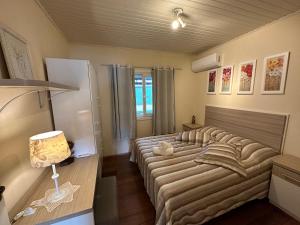 a bedroom with two beds and a refrigerator at Apartamento 2 Quartos até 5 pessoas - Gramado in Gramado