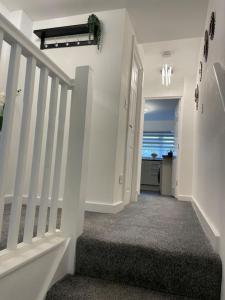 a hallway with a stairway with a white stair case at Luxury Town Center Studio Stevenage in Stevenage