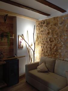 sala de estar con sofá y pared de piedra en Ca la tía Luisa, en Gayanes