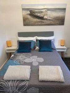 a bedroom with a bed with two pillows and a painting at Luxury Town Center Studio Stevenage in Stevenage