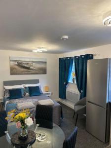 un soggiorno con letto e tavolo con fiori di Luxury Town Center Studio Stevenage a Stevenage