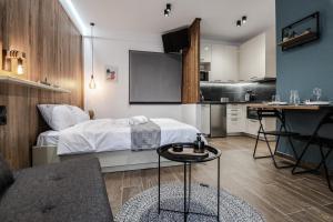 ein Schlafzimmer mit einem Bett und einem Tisch sowie eine Küche in der Unterkunft Cinnamon in Volos