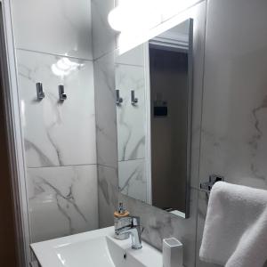 a white bathroom with a sink and a mirror at Artemis House in Limassol