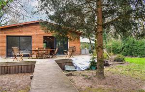 Casa con terraza de madera con mesa y sillas en Beautiful Home In Pradines With Kitchen, en Pradines