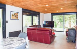 sala de estar con sofá rojo y TV en Beautiful Home In Pradines With Kitchen, en Pradines