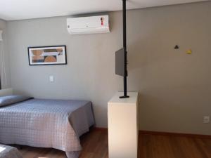 ein Schlafzimmer mit einem Bett und einem TV in der Unterkunft Villa Leopoldina - Studios de aluguel por temporada no Moinhos de Vento in Porto Alegre