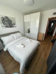 um quarto com uma grande cama branca e 2 toalhas em Queen Caesarea Suite em Caesarea