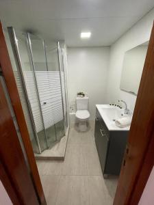 uma casa de banho com um chuveiro, um WC e um lavatório. em Queen Caesarea Suite em Caesarea