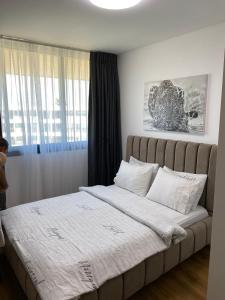 um quarto com uma cama grande com lençóis brancos e uma janela em Queen Caesarea Suite em Caesarea