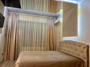 a bedroom with a bed in a room with curtains at Hotel Silver in Sozopol