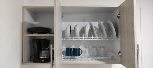 a cabinet with plates and utensils in it at Moderno loft en el centro de Pereira in Pereira +15 photos