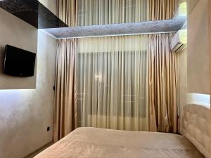 a bedroom with a bed and a window with a television at Hotel Silver in Sozopol