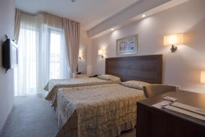 a hotel room with two beds and a table at Hotel Burgas in Burgas