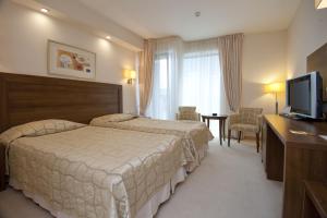 A bed or beds in a room at Hotel Burgas