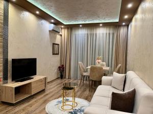 a living room with a couch and a tv and a table at Hotel Silver in Sozopol