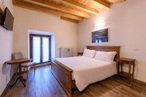 een slaapkamer met een bed, een bureau en een televisie bij il Glicine B&B RISTORANTE in Cazzago San Martino
