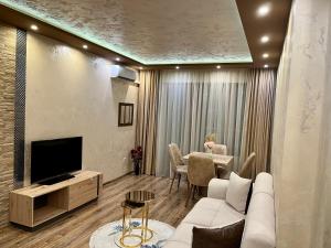 a living room with a couch and a tv and a table at Hotel Silver in Sozopol