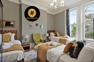 um quarto com três camas e uma placa que diz que é sustentável em 2 Bedroom Apt at Sensational Stay Serviced Accommodation - Kilburn High Road em Londres