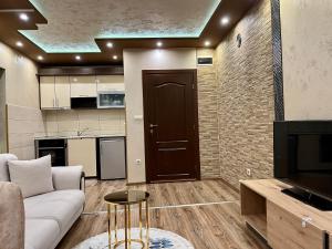 a living room with a couch and a tv at Hotel Silver in Sozopol