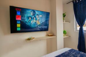 TV de pantalla plana en la pared de un dormitorio en Moderno loft en el centro de Pereira, en Pereira